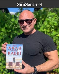 Yacoub Gibran holding up his book The Arab and his Rabbi