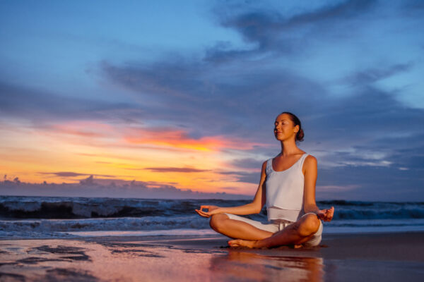Woman meditating on beach