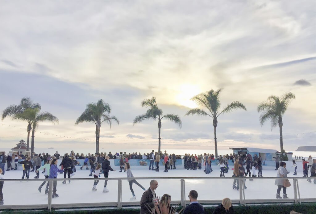 People of all ages ice skating on outdoor ice skating rink.