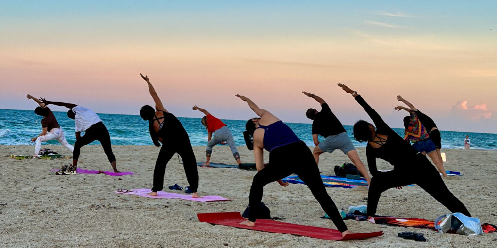 Yoga class on the beach at sunset.