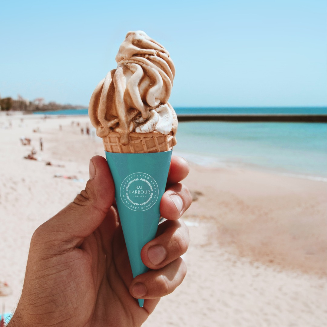 A hand holding an icec cream cone with ice cream. Bal Harbour Village Police.