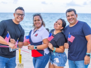 BH 4th of July 2023 135 A family smiling for a picture while on the beach.