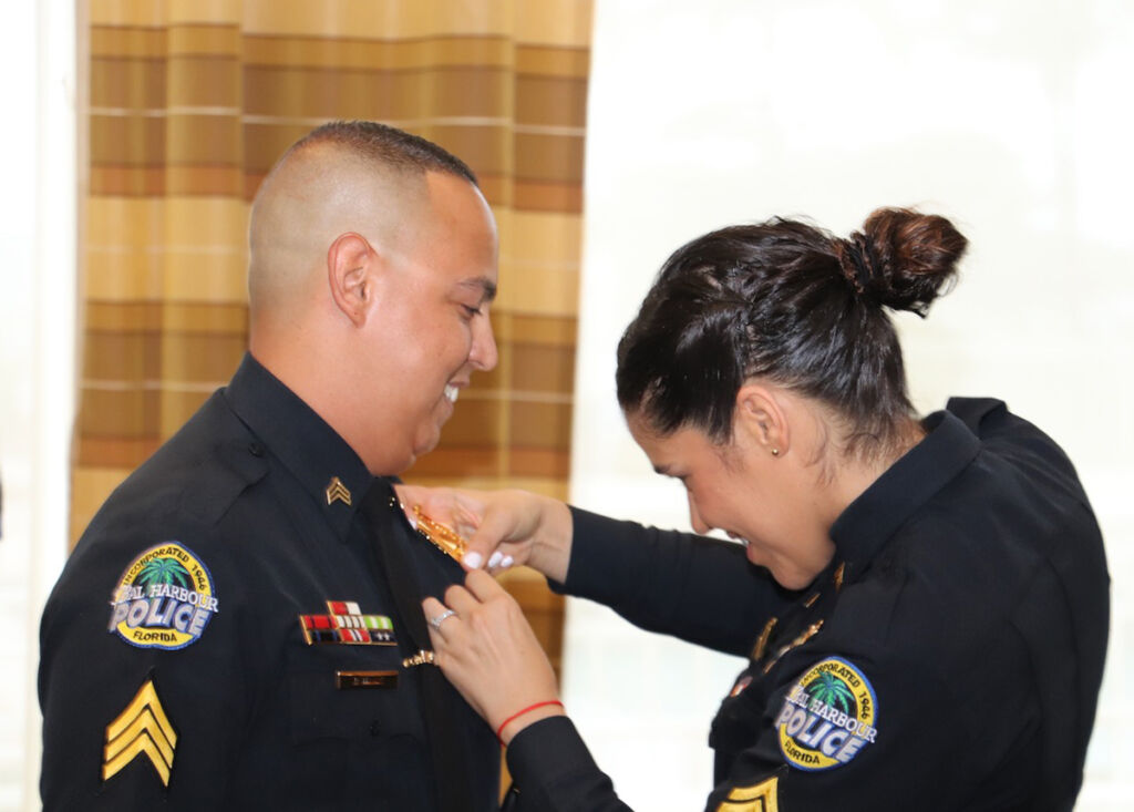 Officer attaching a police pin on another officer.