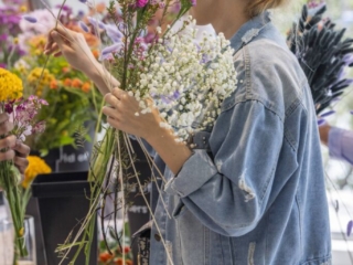 COMPRESSEDFleursDeVilles2024 PARK 03-03-24 _27 (1) A woman from the side, choosing flowers from the assortment.