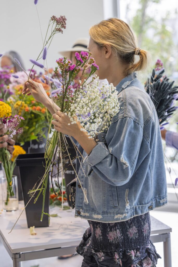 A woman from the side, choosing flowers from the assortment.