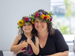 COMPRESSEDFleursDeVilles2024 PARK 03-03-24 _50 (1) A woman and her daughter smiling for the camera, wearing the flower crowns they just made.