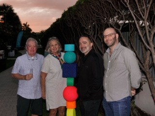 DIC4Compressed A group of residents smiling next to one of the colorful sculptures at the Dreaming In Color Exhibit. The wishing trees are to their right behind them.