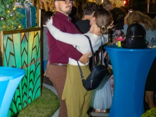 IMG_5947-COMPRESSED A man and woman with their arms wrapped around each other, dancing next to the holiday tree.