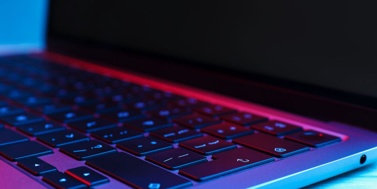 sleek modern laptop and keyboard with vibrant neon light.